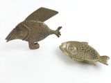 une paire de figurines de poissons en laiton sur fond blanc