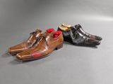 two pairs of men ' s shoes with red bows on them