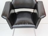 an image of a black leather chair against a white wall