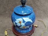 a blue vase with a lid on a wooden stand