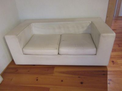 a white couch that is sitting on a hard wood floor