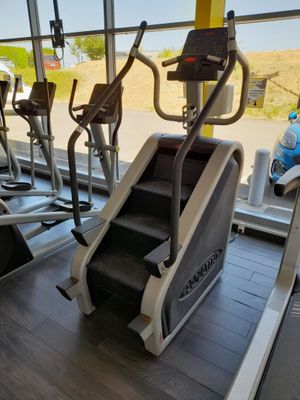 une rangée de vélos d'appartement dans une salle de sport avec vue sur la plage