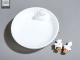 une assiette blanche sur laquelle sont posées deux petites figurines