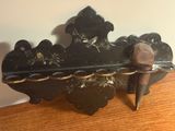 un vieil objet en métal noir orné de fleurs, posé sur une table en bois
