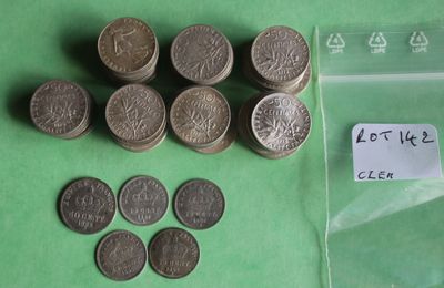 a lot of coins sitting on a table next to a plastic bag