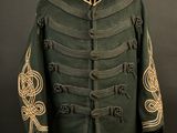 a green military jacket with gold embroiderys on a mannequin stand