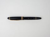 a black and gold fountain pen on a white surface