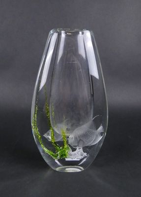 un vase en verre contenant une plante, posé sur une table
