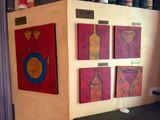 four paintings on the wall of a wine shop