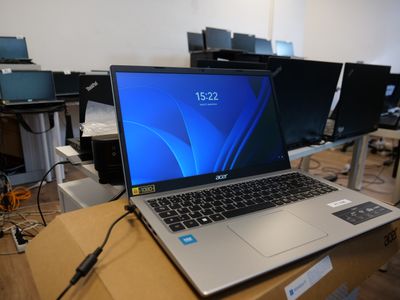 a laptop computer sitting on top of a wooden table