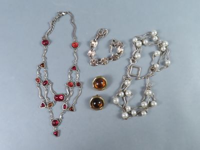 Deux colliers et un bracelet sont posés sur une table