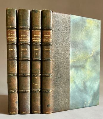trois livres sont empilés sur une table