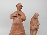 deux figurines en argile représentant une femme et un homme debout l'un à côté de l'autre