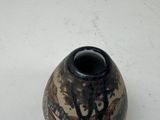 a small vase with a design on it sitting on a table