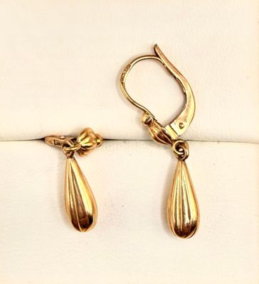 two pairs of gold tone earrings on a white background