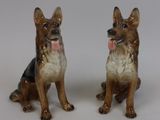 deux figurines de chiens assis l'une à côté de l'autre