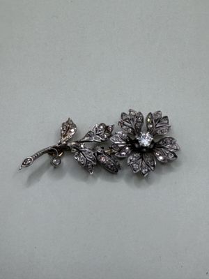 une broche en argent en forme de fleur ornée d'une libellule