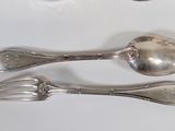 two spoons and a fork on a white table