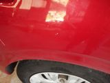 a close up of a red car with a broken tire