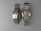 two watches that are sitting next to each other on a table