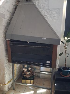 a small oven sitting in the corner of a room next to a potted plant