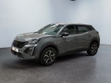 un SUV gris garé dans une pièce aux murs blancs