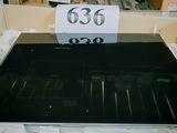 une plaque de cuisson noire sur laquelle est accrochée une étiquette de prix