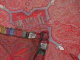 a red and blue paisley pattern on the wall next to a red pillow