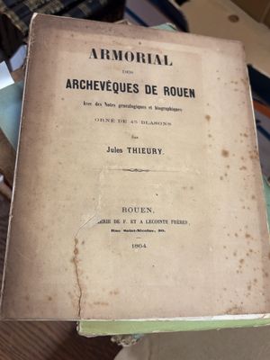 un vieux livre posé sur une table à côté d'une pile de livres