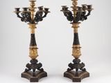 pair of black and gold candelabs on stands on a white background