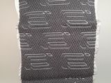 a close up of a black and white knitted scarf hanging on a wall