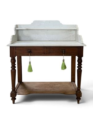 a white marble sink with green tassels hanging from it