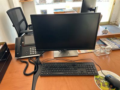 un écran d'ordinateur et un clavier posés sur un bureau dans un bureau à domicile