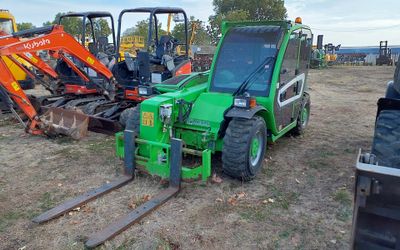 many different types of tractors parked in a field