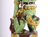 a statue of a green dragon holding a green vase