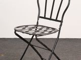 a black metal folding chair with a patterned seat and back
