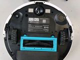 a close up of a robotic vacuum cleaner on a white surface