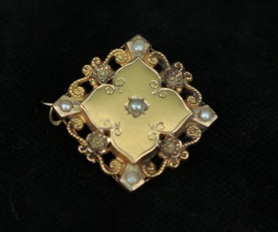 an image of a close up of a broochle on a black surface
