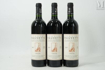 trois bouteilles de vin rouge posées côte à côte sur une table
