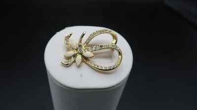 gold tone bow brooch with rhines on top of a white box