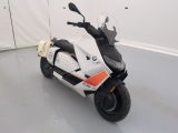 une moto garée dans une pièce aux murs blancs et au sol blanc
