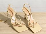 an image of a pair of nude colored sandals on a wooden table