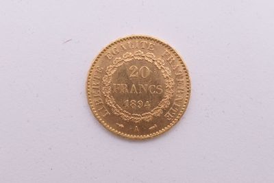 gros plan d'une pièce d'or sur une surface blanche