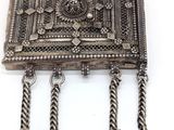 une broche ancienne en argent, avec des clochettes suspendues de chaque côté