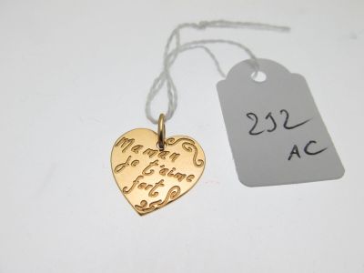 un pendentif en forme de cœur en or auquel est attachée une étiquette de prix