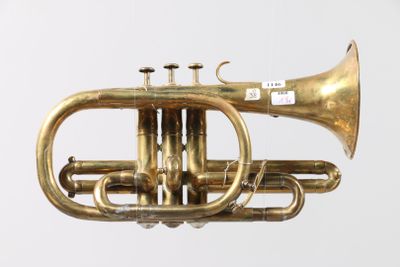 a brass trumpet that is sitting on a white surface