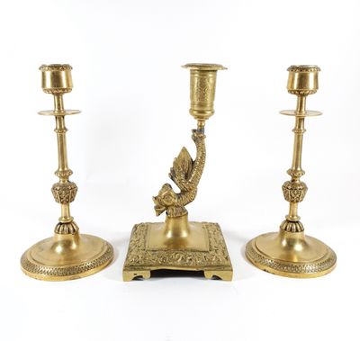 three brass candlesticks with a bird on top of them