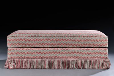 an upholstered ottoman with fringes and fringe trim