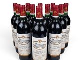 six bottles of red wine lined up in a row on a white surface