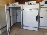 trois réfrigérateurs blancs dans une pièce dont la porte est ouverte